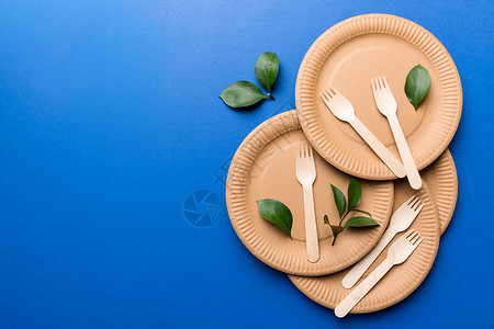 一套空的可重复使用的一次性环保盘子 杯子 淡白色桌子背景的餐具 顶视图 可生物降解的工艺菜肴 回收概念 特写纸板午餐产品勺子刀具背景图片