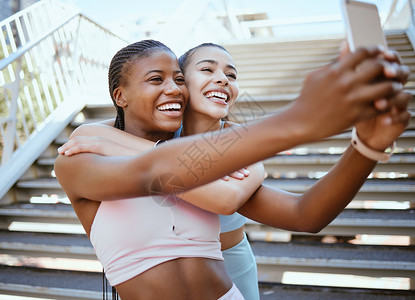 在城市锻炼期间 通过电话锻炼 交朋友和自拍 与快乐 放松的女性结合并大笑 社交媒体 内容创作者和女孩在跑步后在博客上摆姿势进行在背景图片