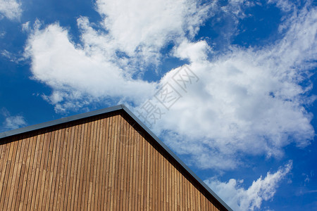 在新的现代房子的屋顶上 与蓝色的天空相对 云彩闪烁背景图片