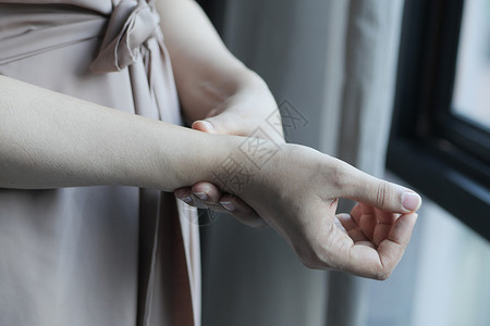 年轻女性的手腕疼痛按摩症状肌肉卫生压力保健疾病手指手臂扭伤背景图片
