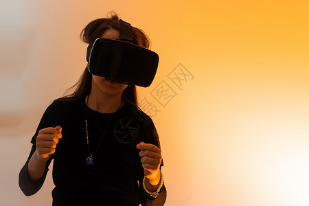 粽情于礼毛笔字一个戴着虚拟现实眼镜头发的少女看电影或玩电子游戏 用双手表达感激之情 有趣的女孩看着 VR 眼镜 手牵着手互联网模拟小样创新耳机背景