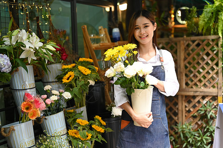 站在花店前手持美丽花束的华丽女花店画像工人高清图片素材