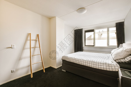 一间小卧室 里面有一张床和梯子背景图片