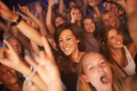音乐会 音乐节和乐队表演中的粉丝 观众和人们在新年庆祝活动中跳舞时充满快乐的能量 在俱乐部现场表演的活动中 女性人群兴奋而疯狂背景图片