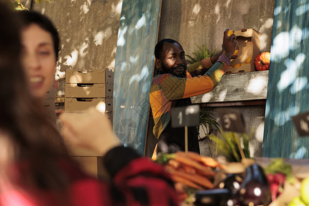 非洲美洲农民市场销售商手持柠檬的销售商顾客高清图片素材
