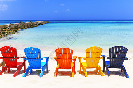 位于阿鲁巴杜斯加勒比的阿鲁巴白沙滩上多彩色木制椅子休闲椅帆船海岸线旅行海滩家具目的地假期风景积水背景图片
