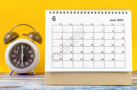 2023年6月的月度案头日历和闹钟背景图片