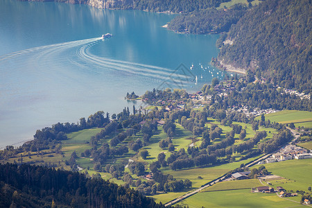 瑞士阿尔卑斯山和通湖的空中观察 日落时乘渡船 因特拉肯山脉日落高地戏剧性码头旅游场景天际天空雪山背景图片