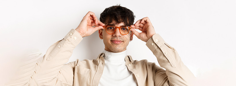 时尚潮人在眼镜店试戴眼镜 戴上眼镜 微笑 站在白色背景上的特写促销生活广告男人情绪商业成功发型黑发学生背景图片