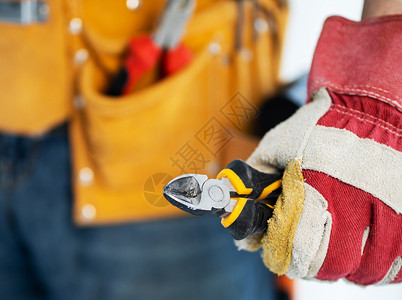 佩戴保护手套的修理工 手持侧切刀建设者高清图片素材
