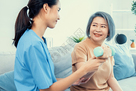 照顾者帮助满足的老年妇女在家用哑铃锻炼运动医学医生病人护士卫生退休康复理疗援助护理老年医学高清图片素材