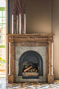 由耐热砖制成的壁炉在顶部衬有不同纹理和颜色的大理石材料 营造出带有 18 世纪时代气息的美丽和威严 独家内饰的一部分背景图片