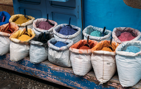 在街市上出售带有不同颜色鲜艳颜料的开袋创意干漆 舍夫沙万市场的街头商店 出售五颜六色的粉状染料背景图片