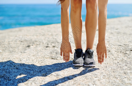 穿鞋做吧 一个年轻女人在阳光明媚的一天 在沙滩上漫步背景图片