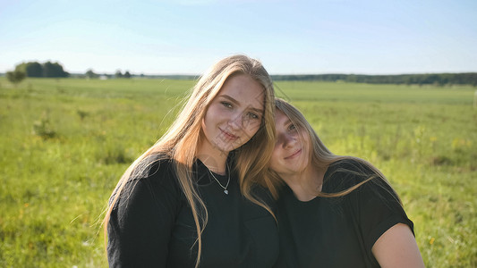 在温暖的夏日 两个姐妹在野外 被一个双姐妹画像女性家庭快乐护理朋友们双胞胎女孩姐妹夫妻皮肤笑高清图片素材
