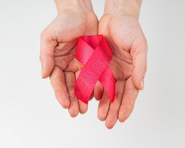 白色背景的红丝带女性手 与艾滋病作斗争的象征 (掌声)背景图片