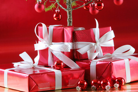 优雅的红色礼物和深厚的红色背景假期季节丝带白色装饰品包装纸玻璃小玩意儿派对背景图片