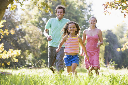 家庭跑户外户外家庭笑着微笑爸爸父母父亲女孩母亲跑步三个人世代妈妈享受背景