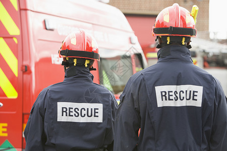 救援队员消防员站在一辆小型消防车旁背景
