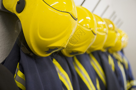 消防员的外套和头盔挂在消防站背景图片