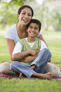 迷之微笑母亲和儿子户外露天在公园里亲吻和微笑背景