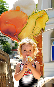 女孩喜欢吃冰淇淋微笑乐趣后代女性甜点孩子小吃对象小女孩食物背景图片
