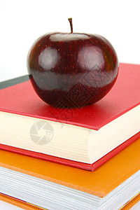 书上的苹果书上苹果教育教师概念学校图书学生学习水果老师红色背景