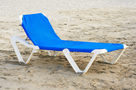 蓝色沙滩椅在荒无人的沙滩上背景