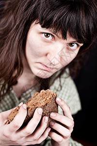 以面包为食的乞丐破产女孩流浪汉社会女士贫困经济机构食物饥饿棕色的高清图片素材