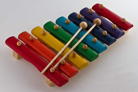 音乐玩具色彩多彩的 Xylophone木琴发声独奏笔记锤子噪音玩具乐趣蓝色橙子背景
