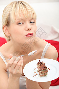 吃着巧克力蛋糕长椅房间饮食喜悦甜点盘子微笑巧克力女性沙发可爱的高清图片素材