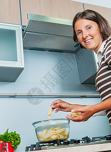 看着正面和烹饪的女孩的肖像用餐食物烤箱厨房饮食平底锅微笑女士房间面条女性高清图片素材