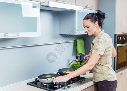 女孩做饭的肖像饮食午餐面条微笑厨房黑发平底锅食物女性营养白色的高清图片素材