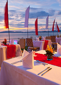 日落时吃晚饭餐厅家具派对假期海岸天空太阳饮料椅子用餐日出高清图片素材