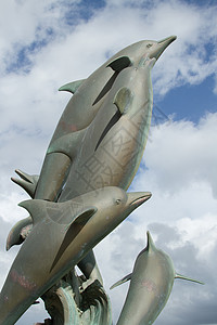 海豚雕塑海豚雕像跳跃蓝色艺术铸件金属天空艺术品哺乳动物团体背景