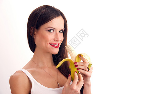 一个黄色香蕉迷人的女人吃RAW香蕉背景