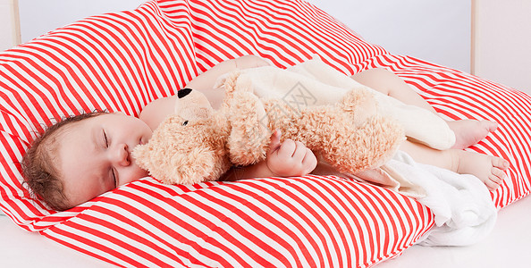 红色条纹枕头睡着的可爱小宝宝 在红色和白条纹枕头上女孩说谎童年眼睛孩子儿子时间压痛婴儿女儿背景
