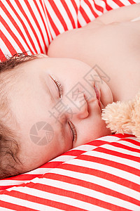 红色条纹枕头睡着的可爱小宝宝 在红色和白条纹枕头上儿子婴儿男生皮肤女孩新生女儿生活就寝说谎背景