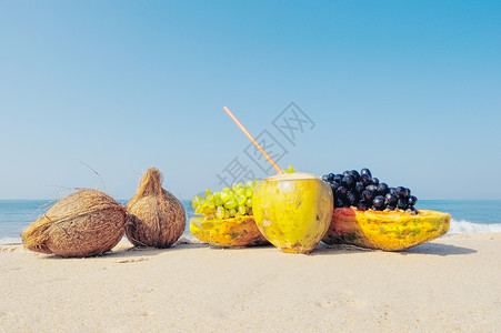 海滩椰子沙地上的水果背景