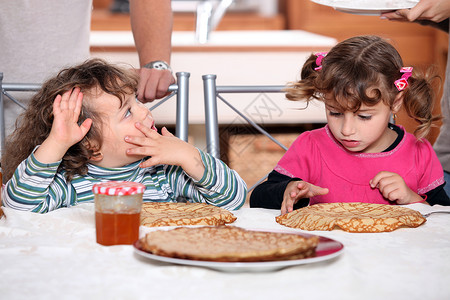 儿童吃煎饼孩子厨房狂欢节早餐姐姐家庭兄弟姐妹橙子兄弟小吃背景图片