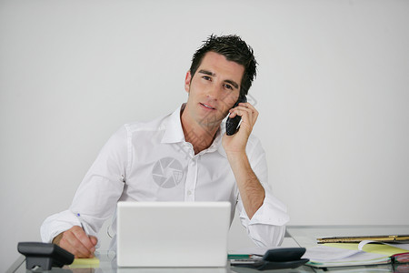 在他的办公桌工作的商务人士人士电话手机男人营销男性经理商务办公室职员对话高清图片素材