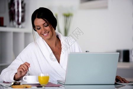 女人在吃早饭橙子女性食物桌子营养杯子果汁电脑快乐牛奶家高清图片素材