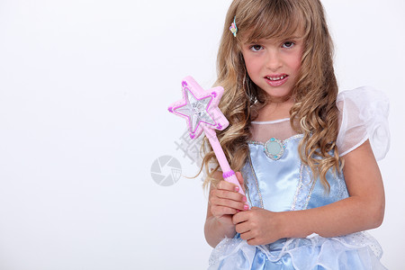 拿魔法棒星星一个穿童话装的小女孩肖像戏服公主派对孩子丝绸乐趣裙子工作室狂欢小姑娘背景