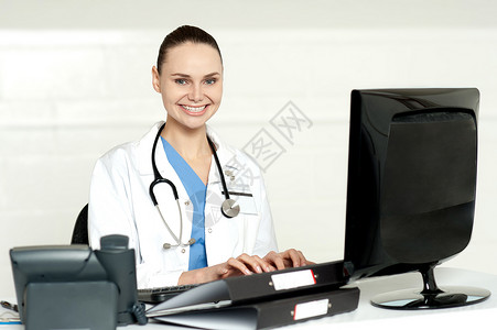 从事计算机工作的微笑女医生实验室外科卫生处方电脑保健护士键盘女士职业坐着高清图片素材