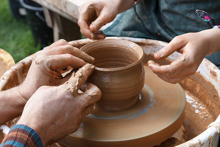 技艺师和学徒陶器教育水壶艺术创造力纺纱领导拇指手指帮助棕色的高清图片素材