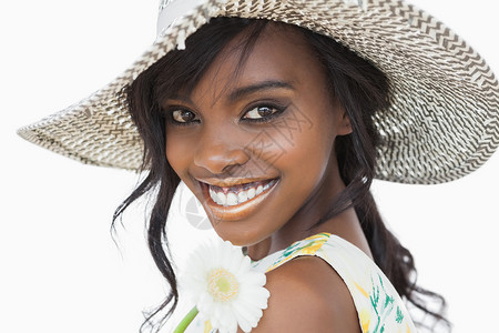妇女微笑 将白花戴在太阳帽子上高清图片