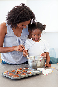 可爱的小女孩 准备饼干与母亲一起吃家庭高清图片素材