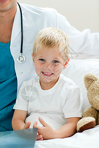 坐在医院床上的 一个微笑的小男孩的肖像生病的高清图片素材