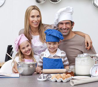 父母在微笑时帮助儿童在厨房烘烤儿子饼干孩子们爸爸母亲食物妈妈男生孩子家庭国内的高清图片素材