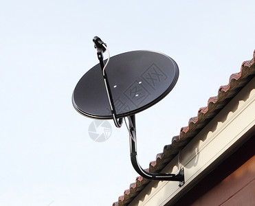 屋顶上的黑色卫星天线盘蓝色的高清图片素材